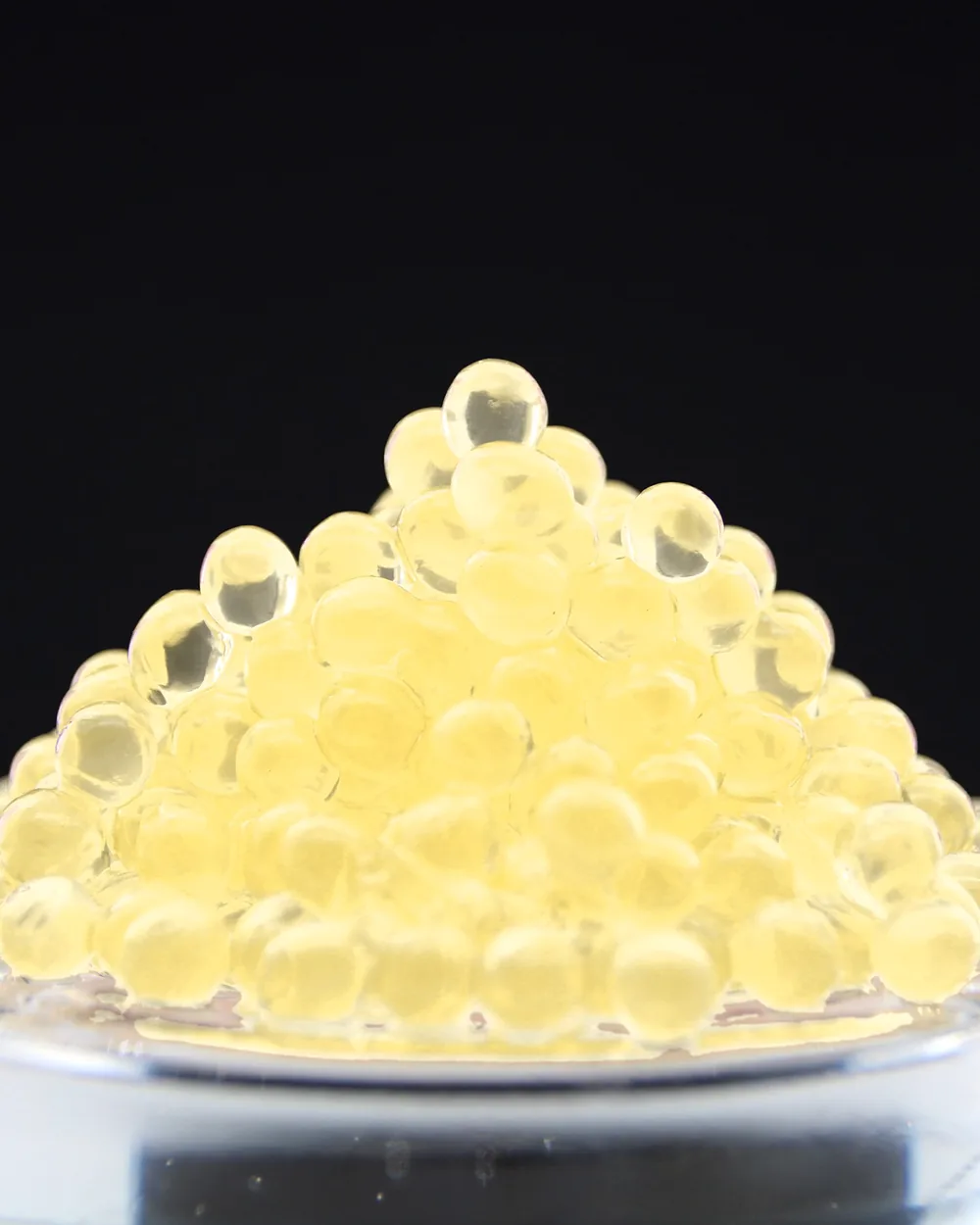 Perles de Pineau des Charentes Blanc, dorées et translucides, en pyramide sur fond sombre